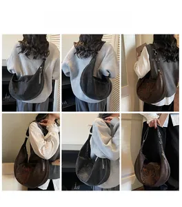 Dettaglio del ricamo floreale sulla borsa a mezzaluna vintage con scritta Maodi