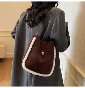 Detail of dark brown bucket bag with white faux shearling trim and silver buckle