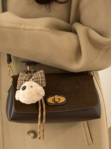 Chic brown suede crossbody bag with gold buckle and cute puppy charm for winter fashion
