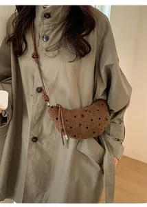 Dettaglio borsa a mezzaluna in tweed marrone con pois neri e fiocchi decorativi