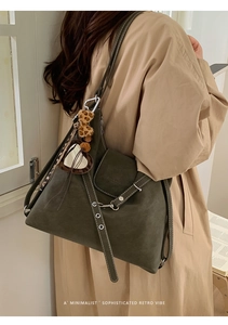Détail du sac cabas en daim vert olive avec coutures contrastées et pendentif ours léopard