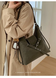 Détail du cabas en daim olive foncé avec boucle argentée et breloque miroir cœur léopard
