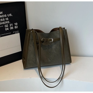 Detail of dark olive green tote bag with vintage matte finish and slim buckle decoration