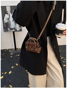 Detailansicht einer Mikro-Umhängetasche mit Leopardenmuster und klassischer Metallschnalle