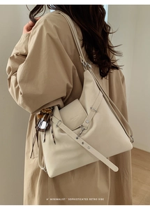 Détail latéral du sac cabas en similicuir crème avec foulard sur un trench-coat