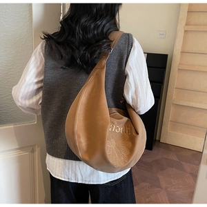 Dettaglio della borsa hobo a mezzaluna marrone con ricamo a margherita e finta pelle liscia