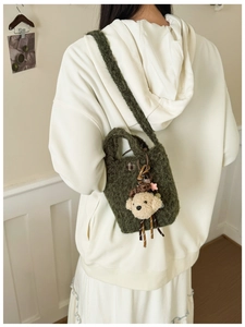 Detailansicht der dunkelgrünen Plüschtasche mit Hund-Anhänger und Strick-Oberfläche