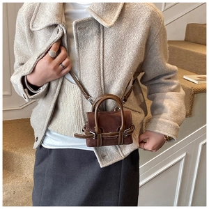 Detailansicht der braunen Mikro-Wildledertasche mit Glattledernähten und Metallschnalle