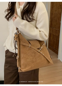 Gros plan sur un sac cabas marron rétro avec lanières croisées et breloque léopard