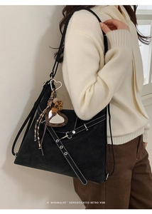 Détail du sac cabas rétro avec coutures contrastées blanches et breloque miroir cœur