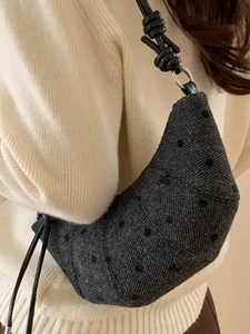 Borsa croissant in tweed grigio con pois e tracolla in pelle annodata su maglione