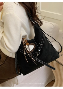 Détail du sac cabas noir avec surpiqûres blanches contrastées et breloque miroir cœur