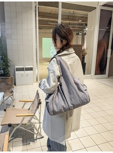 Detailansicht der grauen Nylon-Einkaufstasche mit Plissee-Textur und breitem Gurt