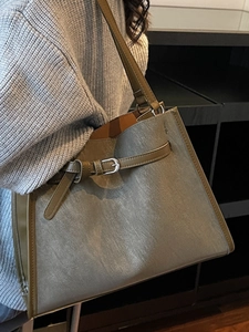 Olive green retro minimalist tote bag with silver buckle strap shown on models shoulder