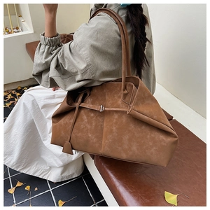 Detailed macro view of caramel tote bag showing the matte suede texture and metal buckle