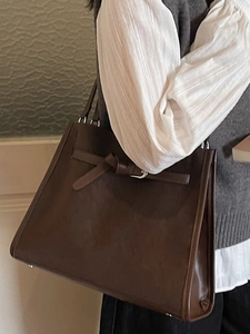 Classic dark brown leather tote bag with buckle detail and knot accent for women