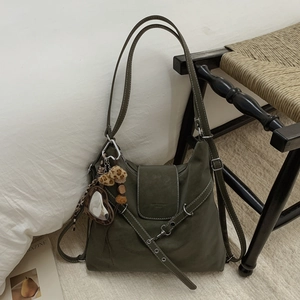 Détail du sac fourre-tout vert olive en cuir mat avec miroir cœur et pompon en peluche