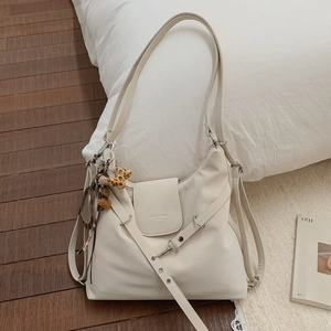 Gros plan du sac cabas beige avec pendentif léopard et bandoulière réglable chic