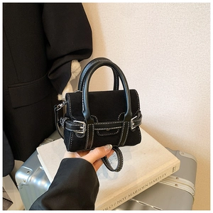 Detail einer schwarzen Umhängetasche mit weißen Nähten und silbernen Schnallendetails