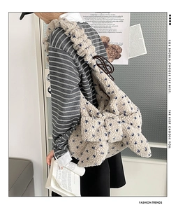 Detail of plush fleece shoulder bag with large bow design and blue floral patterns