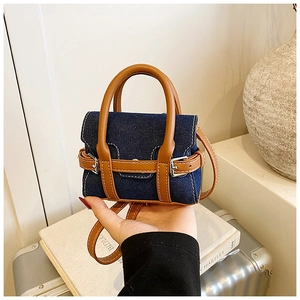 Detailaufnahme der Mini-Denim-Tasche mit Ledergriff und silberner Metallschnalle