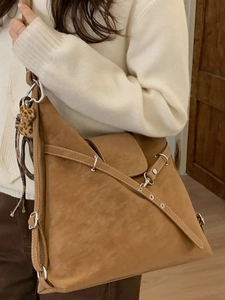 Sac fourre-tout marron vintage avec pompon léopard porté par un mannequin pour l'hiver