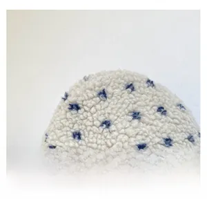 Close-up of soft plush fabric with blue star patterns on a white fleece handbag