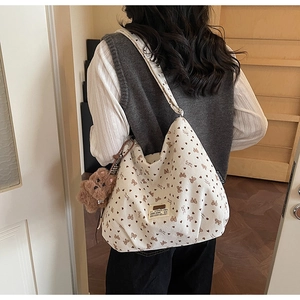 Detail of off-white corduroy tote bag featuring brown bow and heart floral patterns