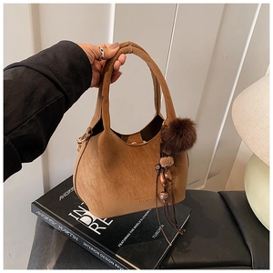 Détails du sac hobo en daim marron avec pompon, perles en bois et pompons en cuir souple