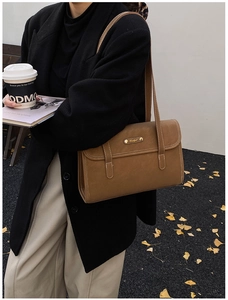 Detail of caramel faux leather shoulder bag with decorative buckles and contrast stitching