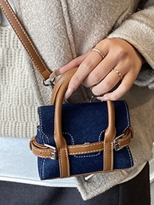 Mini-Handtasche aus Denim und braunem Leder mit Silberschnallen, von Model gehalten