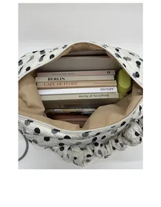 Spacious interior of white quilted tote bag holding books and personal essentials