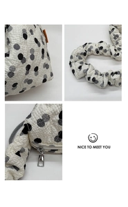 Macro detail of bubble textured fabric and polka dot pattern with ruffled shoulder strap