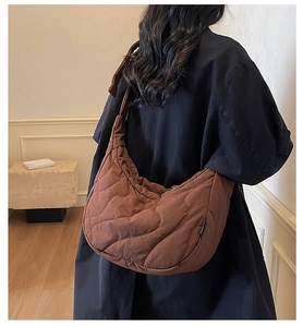 Detail of coffee brown quilted wave pattern shoulder bag shown on model for sizing