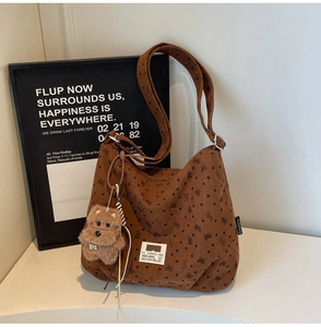 Detail of vintage brown corduroy tote with black bow and heart patterns plus puppy charm