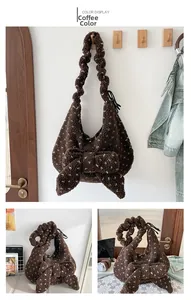 Detail view of the soft brown plush bag featuring a large decorative bow and ruffles
