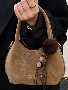 Sac seau vintage en daim kaki avec pendentif pompon marron et poignée supérieure