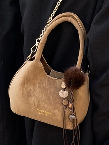 Sac seau vintage en daim marron avec chaîne dorée et breloque à pompon en peluche chic