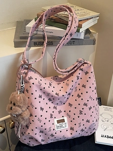 Pink corduroy tote bag with black bow print and cute plush puppy keychain accessory