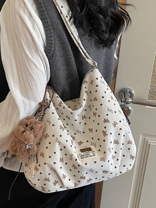 White corduroy tote bag with bear and heart prints featuring a plush dog charm