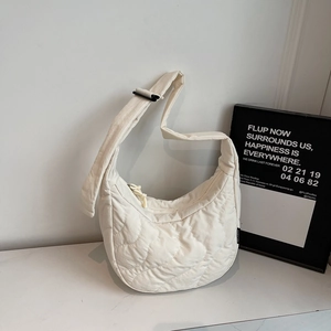 Detailed view of white quilted hobo bag in soft nylon with wavy pattern and sleek zipper