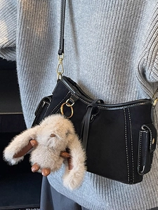 Retro black crossbody bag with white stitching and plush bunny charm detail