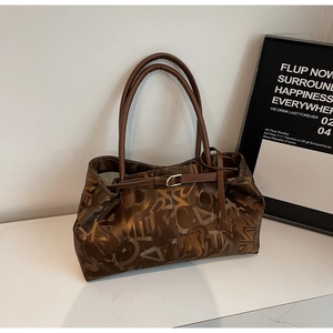 Close-up of brown vintage tote bag with letter print and metal buckle detail