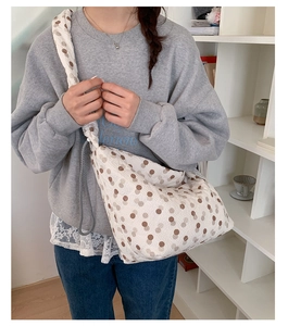 Detail of Korean style polka dot cloud bag featuring pleated beige fabric and wide strap