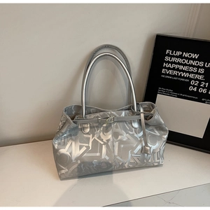 Detail shot of the metallic silver tote bag texture with abstract geometric patterns