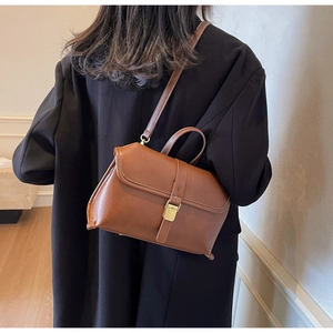 Rückansicht eines Models mit brauner Vintage PU-Lederhandtasche und goldener Metallschnalle