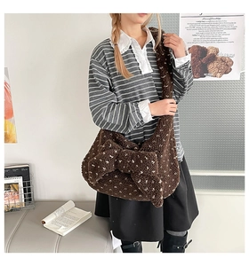 Detailed shot of dark brown plush crossbody bag with white floral print and large bow