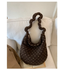 Dettaglio della borsa hobo in peluche marrone scuro con cuori bianchi e tracolla arricciata
