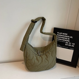 Close-up of olive green quilted hobo bag with adjustable strap and wavy stitching detail