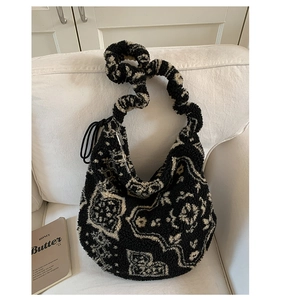 Dettaglio della borsa hobo in peluche con motivo bianco e nero e tracolla arricciata